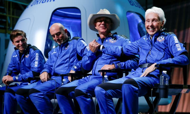 FILE PHOTO: Billionaire American businessman Bezos shakes hands with Wally Funk, who became the oldest person in space, at a post-launch press conference after they flew on Blue Origin's inaugural flight to the edge of space, in Van Horn