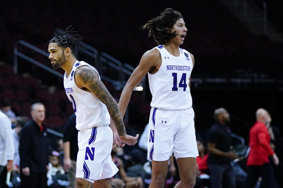 Northwestern's Boo Buie (0) celebrates with teammate Casey Simmons (14) during the first half of an NCAA college basketball game against Georgia Tuesday, Nov. 23, 2021, in Newark, N.J. (AP Photo/Frank Franklin II)