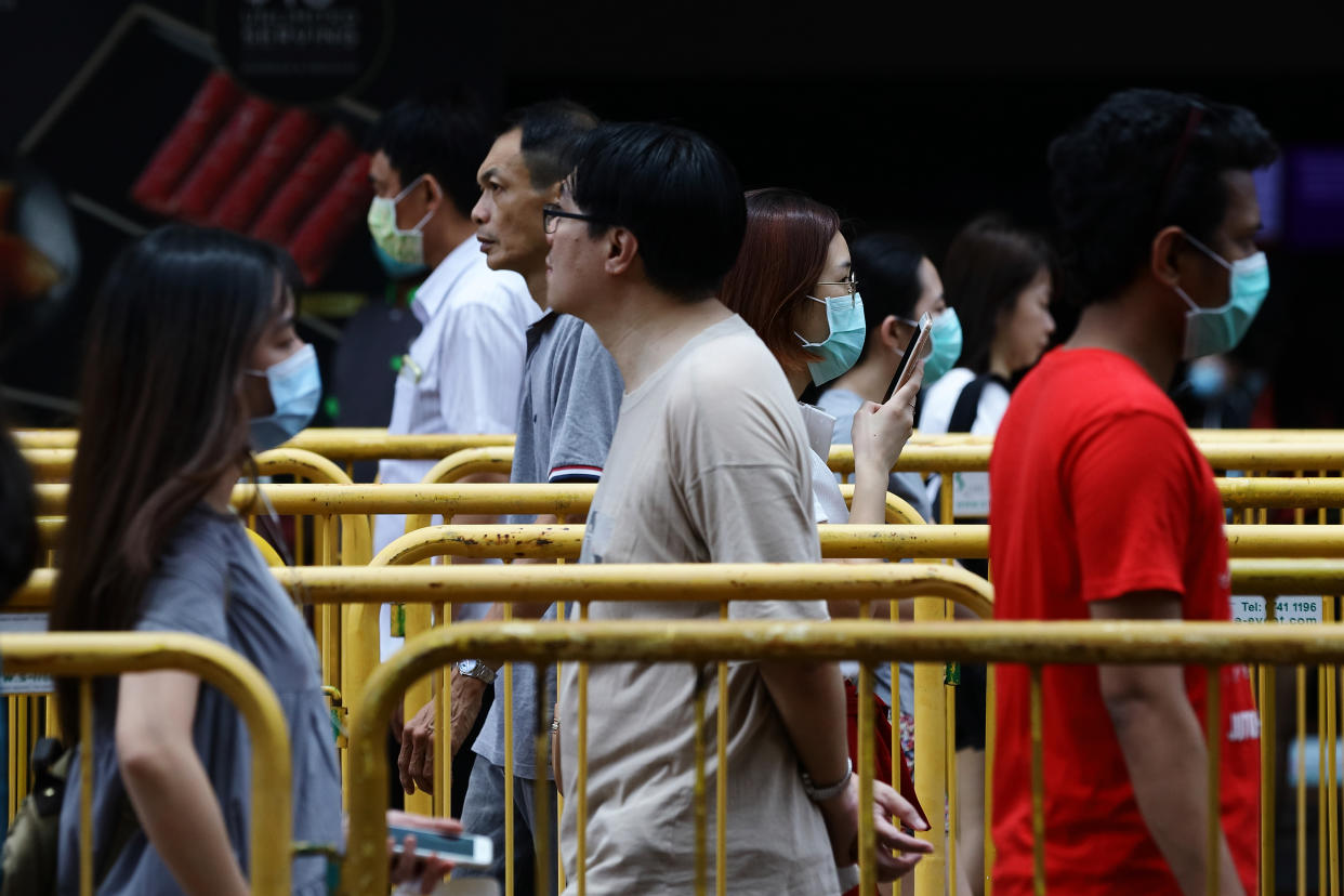 SINGAPORE - MARCH 28:  Shoppers wearing protective mask queue to enter a shopping mall with a social distancing markers in place on March 28, 2020 in Singapore.  Singapore government introduced a supplementary budget on March 26 with measures worth S$48 billion to support Singaporeans and businesses to cope with the Covid-19 pandemic.  (Photo by Suhaimi Abdullah/Getty Images)