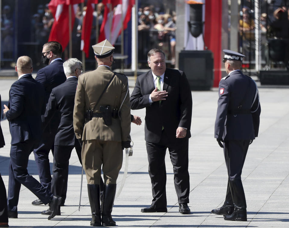 U.S. Secretary of State Mike Pompeo gestures toward Polish soldiers during ceremonies marking the centennial of the Battle of Warsaw, a Polish military victory in 2020 that stopped the Russian Bolshevik march toward the west, in Warsaw, Poland, Saturday Aug. 15, 2020. Pompeo attended as he wrapped up a visit to central Europe.(AP Photo/Czarek Sokolowski)