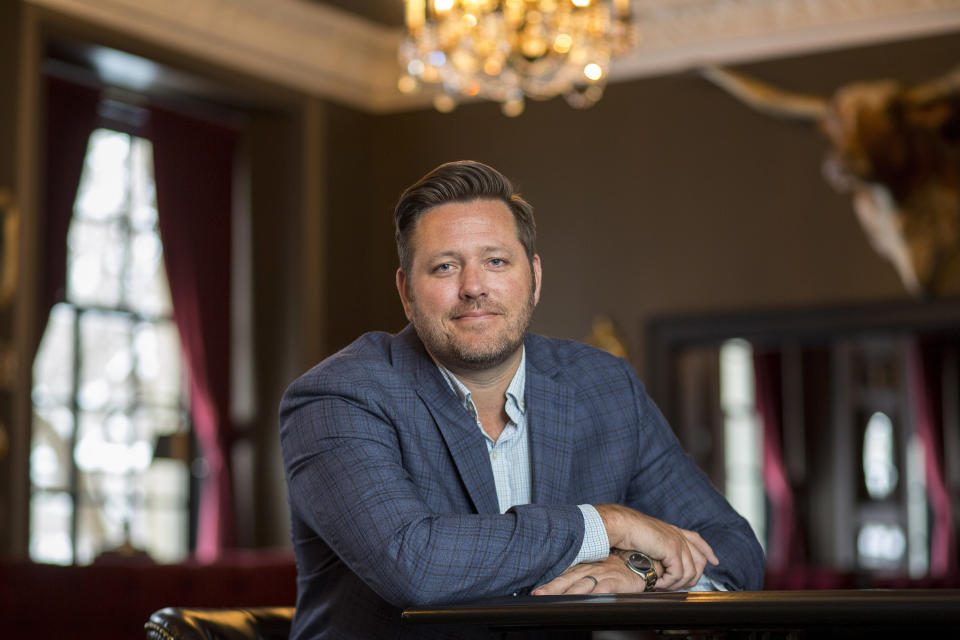 In this Feb. 11, 2020, photo, Brent Frederick, founder of Jester Concepts, a restaurant group in Minneapolis poses at P.S. Steak. Frederick puts a 3% voluntary surcharge on guest checks to help pay for health insurance and mental health services and says almost all guests agree to pay it. (AP Photo/Andy Clayton-King)