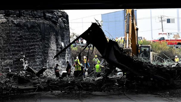 PHOTO: Workers inspect and clear debris from an elevated section of Interstate 95 that collapsed the previous day in Philadelphia on June 12, 2023. (Mark Makela/Getty Images)