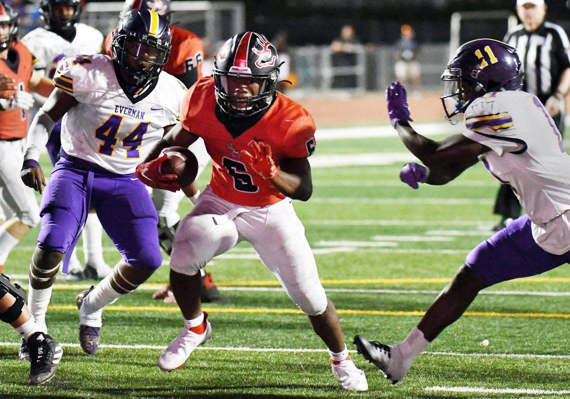 Burleson’s Jabari Smith, center runs between Everman’s Cortez Dunigan, left and Howard Evans-Sauls for the touchdown to cut the lead 26-28 in the fourth quarter of Thursday’s October 13, 2022 District 5-5A Division 2 football game at Burleson ISD Stadium in Burleson, Texas. Everman went on to win 28-26. Special/Bob Haynes