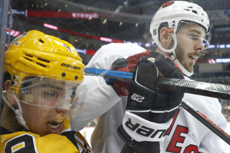 Pittsburgh Penguins' Evan Rodrigues (9) is checked by Carolina Hurricanes' Joel Edmundson (6) along the boards by during the second period of an NHL hockey game, Sunday, March 8, 2020, in Pittsburgh. The Hurricanes won 6-2. (AP Photo/Keith Srakocic)