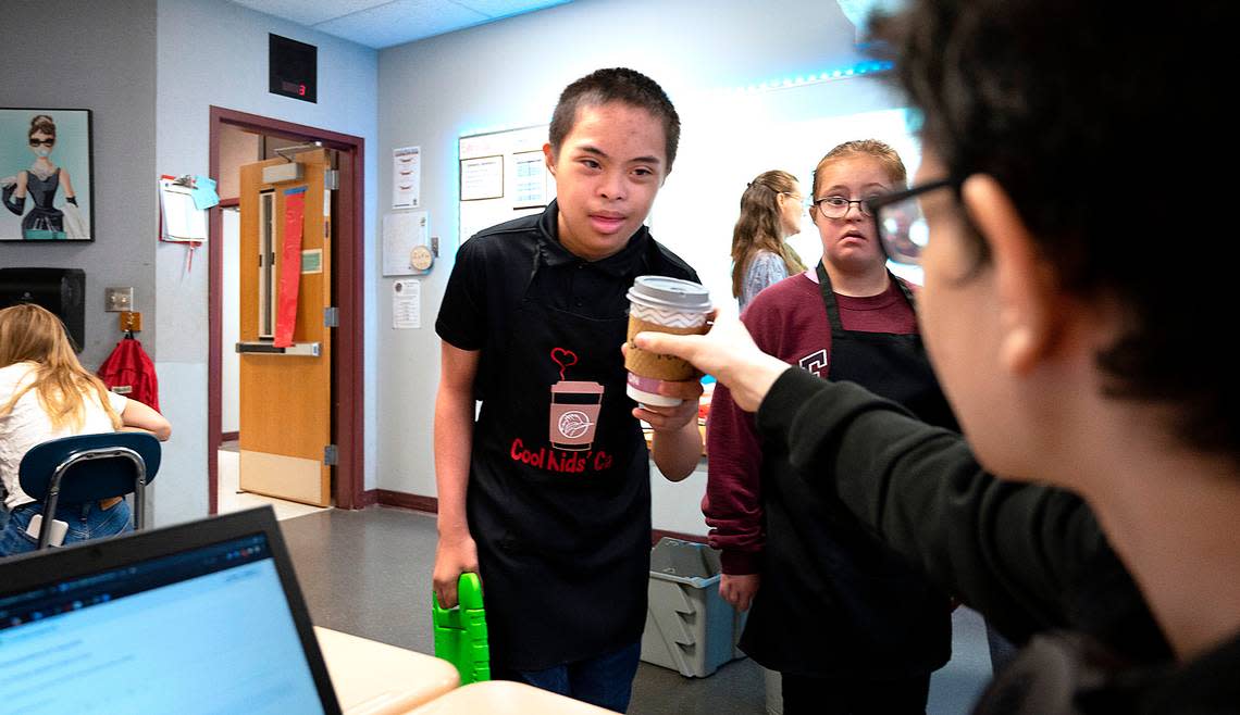 Hans Cagabcab delivers a hot chocolate to a classroom along with partner Kate Buerer as part of the Cool Kids Cafe project at Goodman Middle School in Gig Harbor, Washington, on Thursday, Sept. 15, 2022.