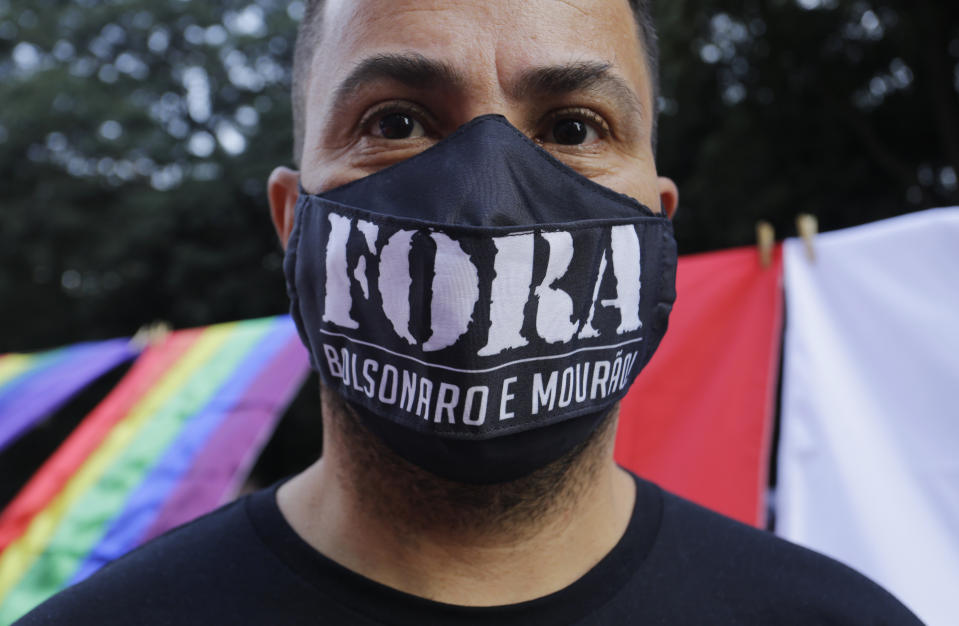 A demonstrator wears a face mask with a message that reads in Portuguese; "Get out Bolsonaro and Mourao" during a protest demanding Bolsonaro resign, in Sao Paulo, Brazil, Saturday, July 3, 2021. Activists called for nationwide demonstrations against Bolsonaro, gathering protestors to demand his impeachment amid allegations of potential corruption in the Health Ministry’s purchase of COVID-19 vaccines. (AP Photo/Nelson Antoine)