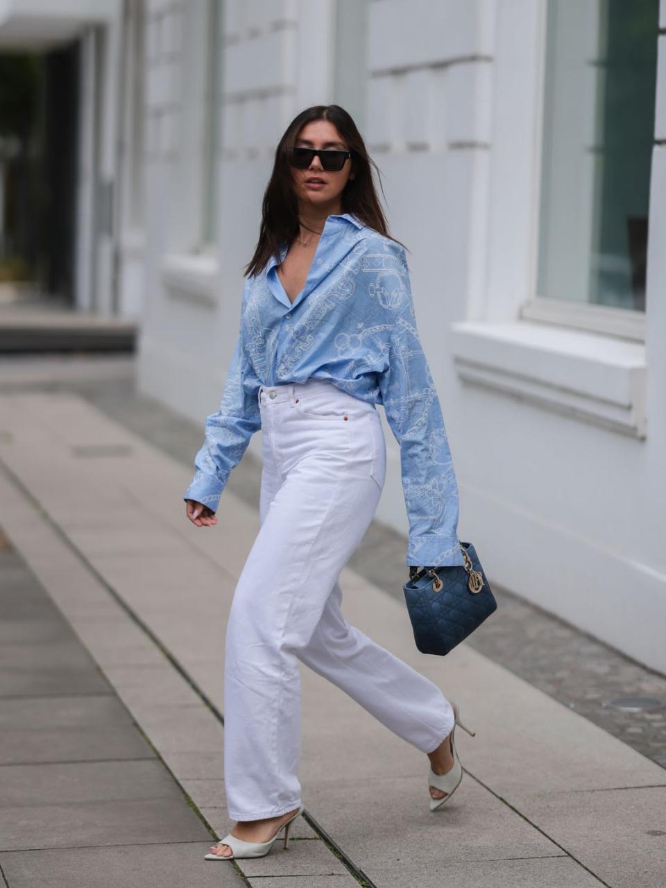 Milena Karl wears white jeans with a pale blue slouchy shirt 