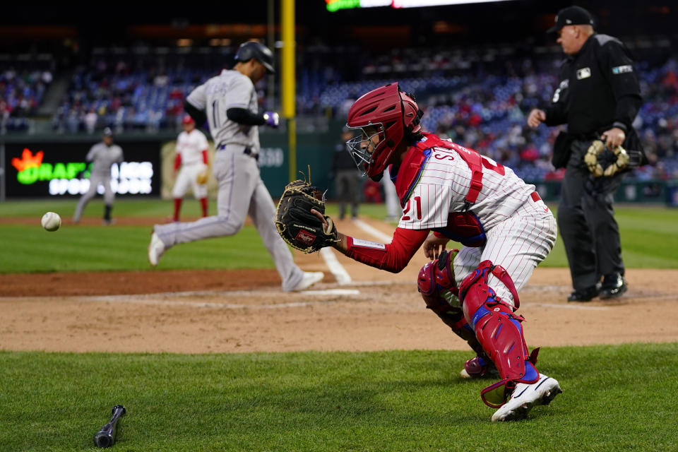 Philadelphia Phillies catcher Garrett Stubbs, right, catches the ball as Colorado Rockies' Jose Iglesias scores on a run-scoring single by Connor Joe during the third inning of a baseball game, Wednesday, April 27, 2022, in Philadelphia. (AP Photo/Matt Slocum)