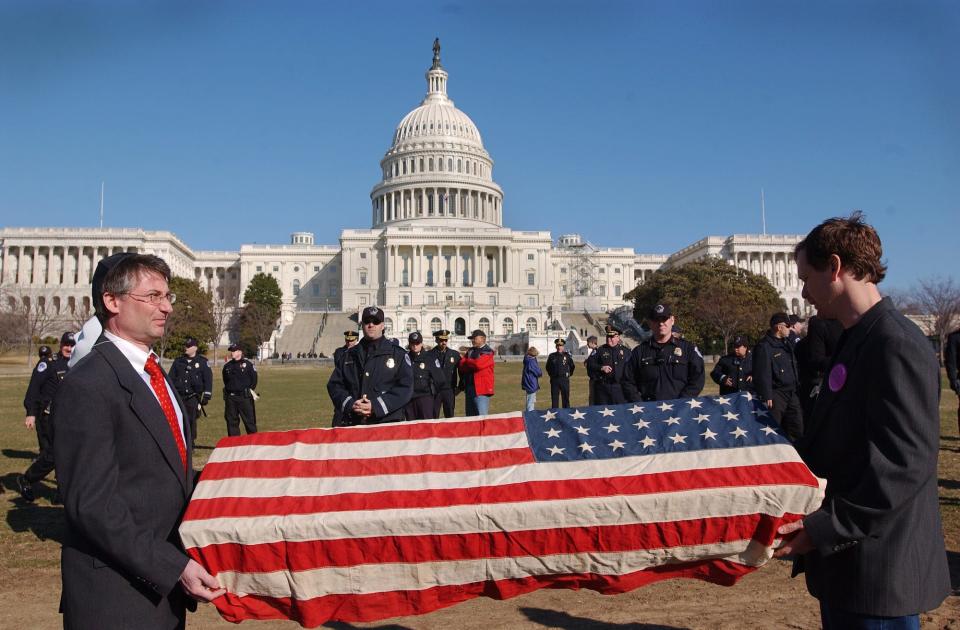 On March 9, 2003, Jim Schulman, left, and Michael Beer, both of Washington, D.C., hold a mock coffin draped with an American flag near the U.S. Capitol during a protest opposing a possible war with Iraq.