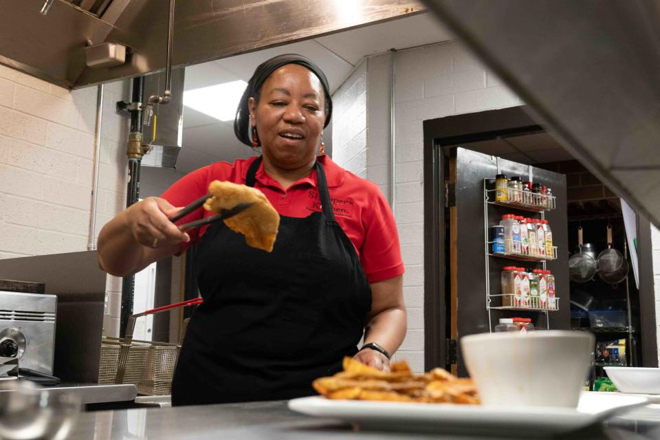 Sylvia Hopper, owner and chef at SHopper's Kitchen and Vista Event Center, removes a freshly fried piece of catfish for an order Tuesday. Hopper says the catfish is available Tuesdays, Saturdays and Sundays as long as she can get the large filets she prefers.
