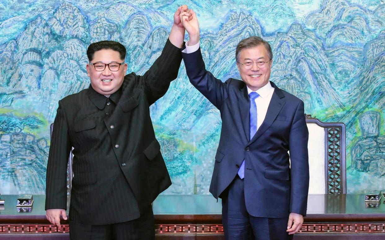 North Korean leader Kim Jong Un, left, and South Korean President Moon Jae-in raising their hands after signing a joint statement at the border village of Panmunjom, April 27 2018 - Korea Summit Press Pool