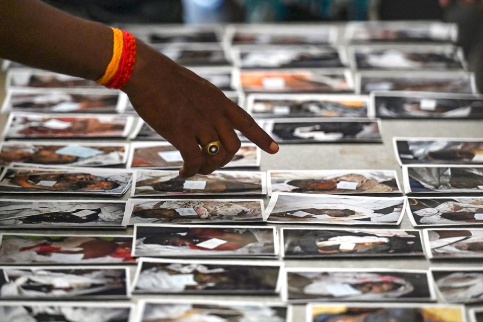 A victim's family member looks at photographs to identify the body at the temporary mortuary (AFP via Getty Images)