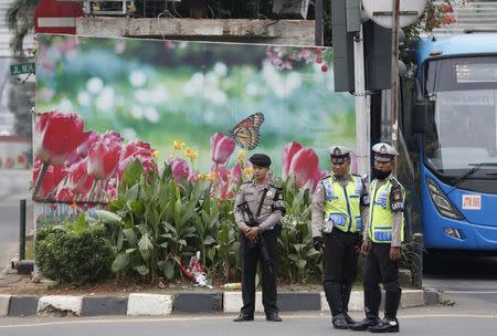 Indonesian police stand beside a damaged police box, at the site of this week's militant attack in central Jakarta, Indonesia January 16, 2016. REUTERS/Darren Whiteside