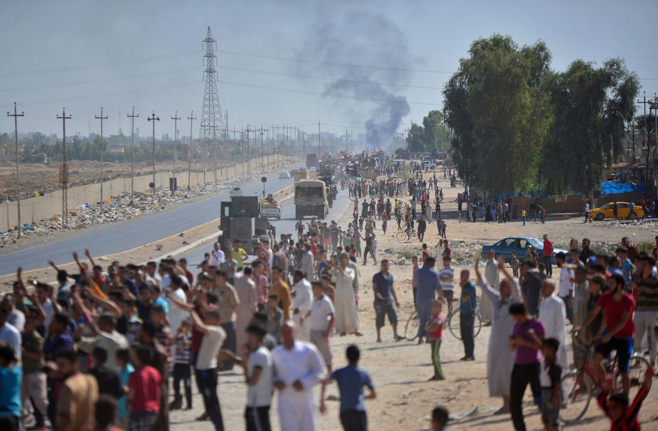 <p>Iraqi people gather on the road as they welcome Iraqi security forces members, who continue to advance in military vehicles in Kirkuk, Iraq, Oct. 16, 2017. (Photo: Stringer/Reuters) </p>