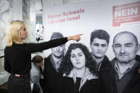 Laura Zimmermann, Co-President of Operation Libero, is standing in front of a poster reading 'No. No Switzerland is an island." at the meeting place of the opponents of the popular initiative "For moderate immigration" (the limitation initiative), on Sunday, 27 September 2020, at the Hotel Schweizerhof in Bern, Switzerland. (Peter Klaunzer/Keystone via AP)