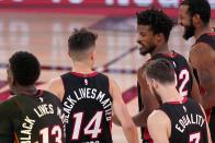 Miami Heat's Bam Adebayo (13), from left, Tyler Herro (14), Goran Dragic, right front, Jimmy Butler, from second right and Andre Iguodala, right, walks off the court celebrating their 112-109 win in Game 4 of an NBA basketball Eastern Conference final against the Boston Celtics on Wednesday, Sept. 23, 2020, in Lake Buena Vista, Fla. (AP Photo/Mark J. Terrill)