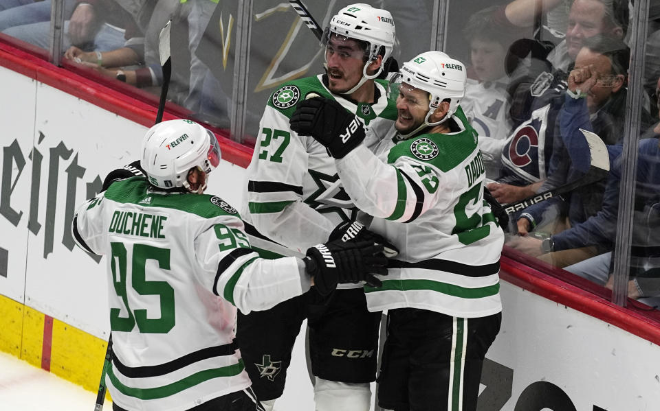 Dallas Stars center Matt Duchene, left, and left wing Mason Marchment, center, congratulate right wing Evgenii Dadonov after his goal in the third period of Game 4 of an NHL hockey Stanley Cup playoff series against the Colorado Avalanche, Monday, May 13, 2024, in Denver. (AP Photo/David Zalubowski)