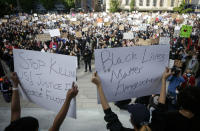 Demonstranten halten auf einer Kundgebung Schilder mit der Aufschrift "Stop killing us." und "Black lives matter everywhere" in die Höhe. Foto: Liang Sen / Xinhua / dpa