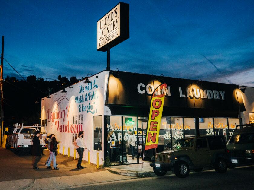 The exterior of a laundromat lighted up at twilight