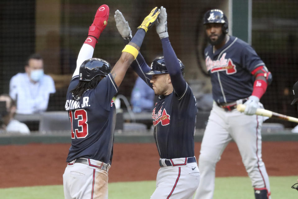 Atlanta Braves first baseman Freddie Freeman, right, celebrates his two-run home run with teammate Ronald Acuna (13) against the Los Angeles Dodgers during the fourth inning in Game 2 Tuesday, Oct. 13, 2020, in the best-of-seven National League Championship Series at Globe Life Field in Arlington, Texas. (Curtis Compton/Atlanta Journal-Constitution via AP)