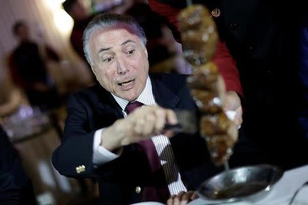 El presidente de Brasil, Michel Temer, en un asado con embajadores de países importadores de carne en Brasilia, mar 19, 2017. El impacto por el escándalo de corrupción en la industria cárnica brasileña se extendió el lunes, después de que China y Corea del Sur suspendieron algunas importaciones, la Unión Europea anunció que estudiaba acciones y los títulos de los frigoríficos BRF y JBS cayeron con fuerza. REUTERS/Ueslei Marcelino