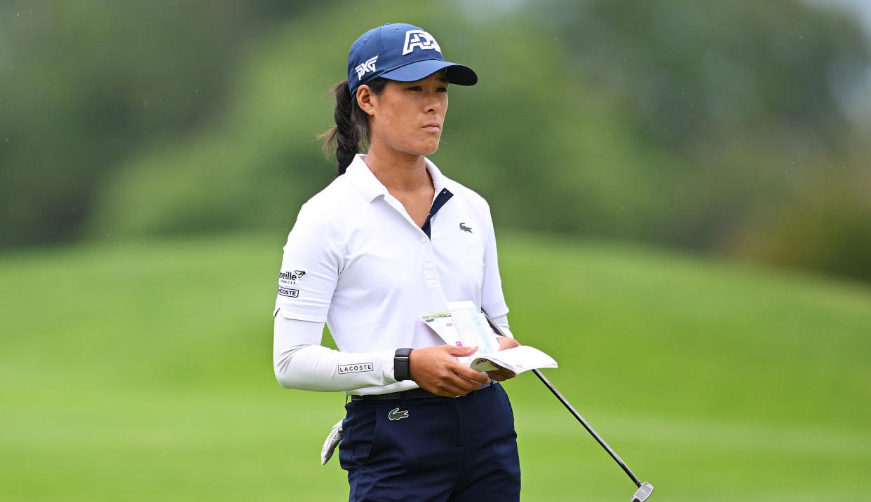  Boutier waits on the fairway whilst holding her yardage book 