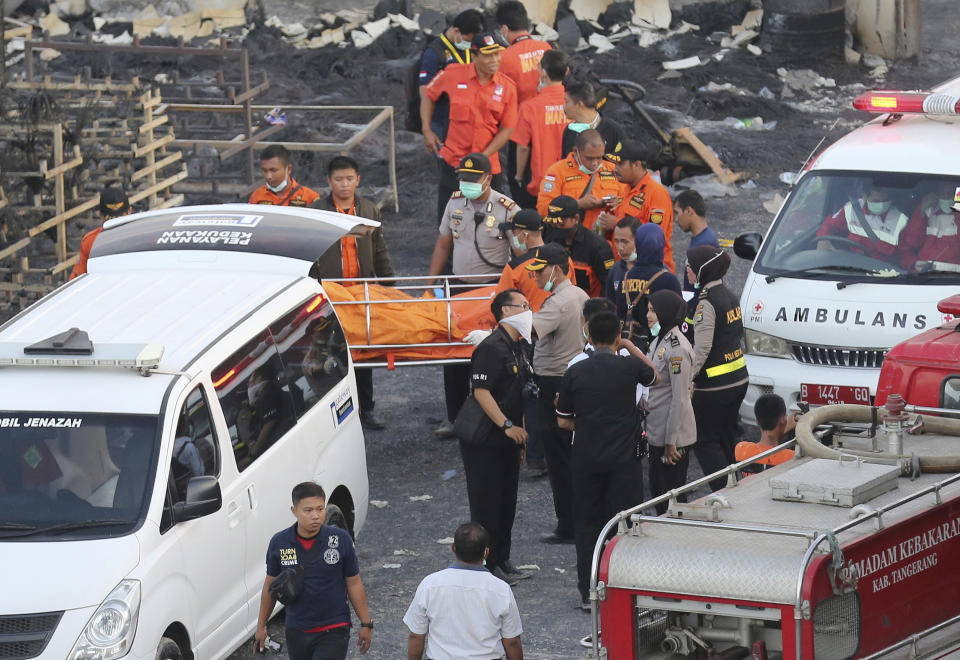 <p>Police officers and rescuers carry a body at the site of an explosion at a firecracker factory in Tangerang, on the outskirts of Jakarta, Indonesia, Thursday, Oct. 26, 2017. The explosion and raging fire killed a number of people and injured dozens, police said. (Photo: Tatan Syuflana/AP) </p>