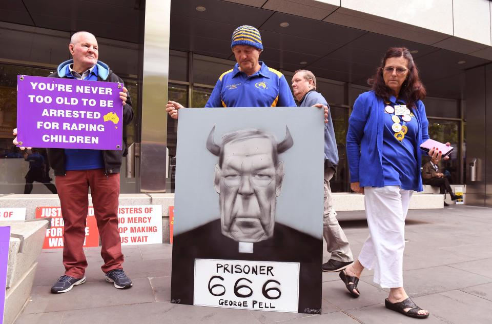 Survivors of church abuse hold placards outside at the County Court to hear the sentencing of Cardinal George Pell who was was found guilty on historic child sex crimes, in Melbourne on March 13, 2019.