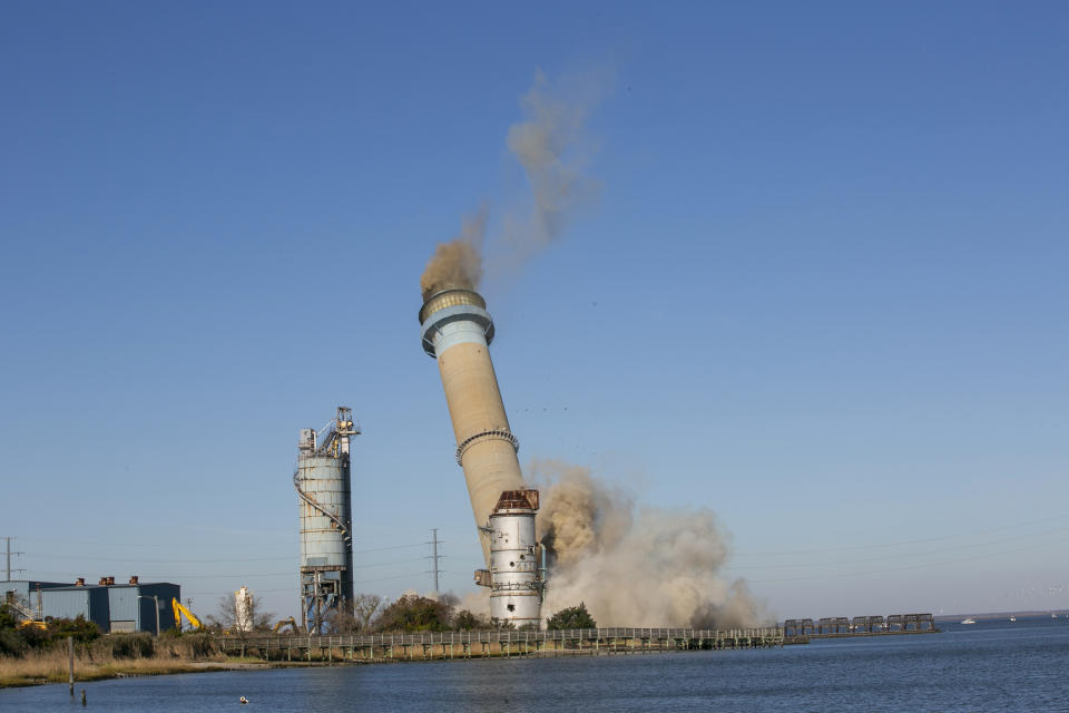 The smokestack at the former B.L. England Generating Station, a coal and oil burning power plant in Upper Township, N.J., is toppled during a control demolition on Thursday, October 26, 2023. The site will be redeveloped as a mixed-use residential and commercial project, and a nearby electrical substation will be used to connect New Jersey's soon-to-come offshore wind farms with the electrical grid. (AP Photo/Ted Shaffrey)