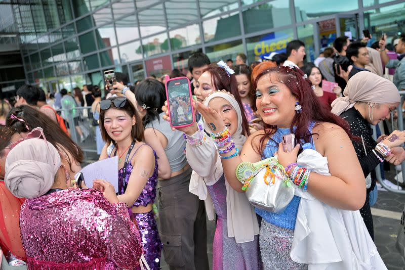 Taylor Swift's fans, or Swifties, take a photo at the National Stadium for Swift's Eras Tour concert in Singapore