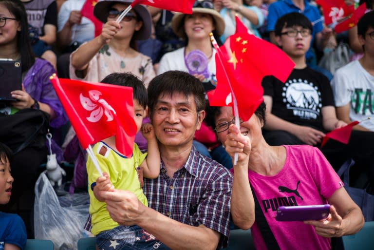 People react as they raise Chinese and Hong Kong flags during the open day of the Chinese People's Liberation Army (PLA) Navy Base at Stonecutter Island in Hong Kong on July 1, 2016