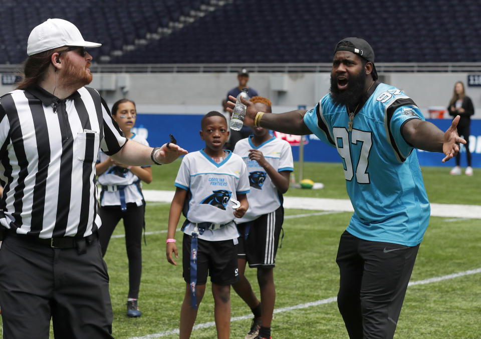 NFL player Mario Addison of the Carolina Panthers complains to the referee as he coaches a young team during the final tournament for the UK's NFL Flag Championship, featuring qualifying teams from around the country, at the Tottenham Hotspur Stadium in London, Wednesday, July 3, 2019. The new stadium will host its first two NFL London Games later this year when the Chicago Bears face the Oakland Raiders and the Carolina Panthers take on the Tampa Bay Buccaneers. (AP Photo/Frank Augstein)