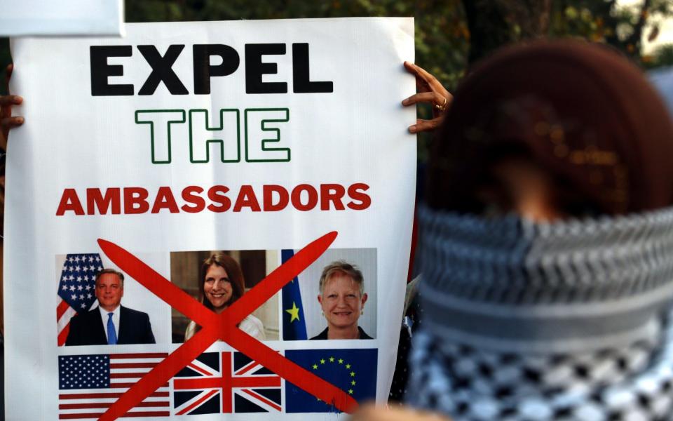 People carry placards demanding the expulsion of the ambassadors of the US, UK, and EU during a protest against Israel in Islamabad, Pakistan