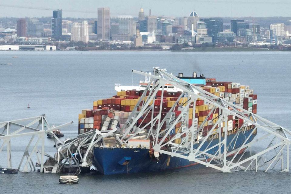 <p>JIM WATSON/AFP via Getty </p> The steel frame of the Francis Scott Key Bridge sits on top of a container ship after the bridge collapsed in Baltimore, Maryland, on March 26, 2024