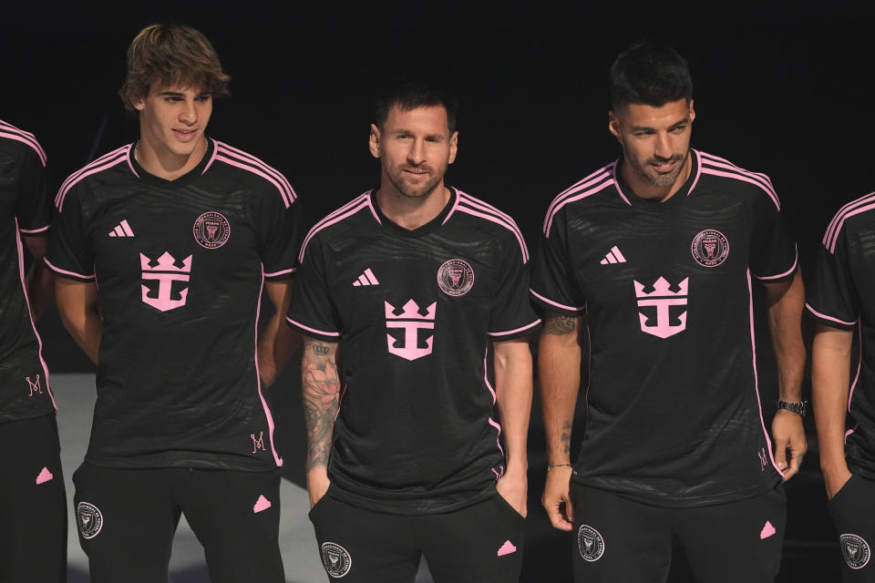 Inter Miami soccer player Lionel Messi, center, stands with his teammates Benjamin Cremaschi, left, and Luis Suarez, right, as they wear new uniforms with the Royal Caribbean International logo during an event on the world's largest cruise ship Icon of the Seas, Tuesday, Jan. 23, 2024, in Miami. The MLS soccer team Inter Miami CF has formed a partnership with the cruise line Royal Caribbean International. (AP Photo/Lynne Sladky)