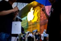 FILE PHOTO: A man holds a bag with a new iPhone inside as Apple's new iPhone 15 officially goes on sale across China, in Shanghai