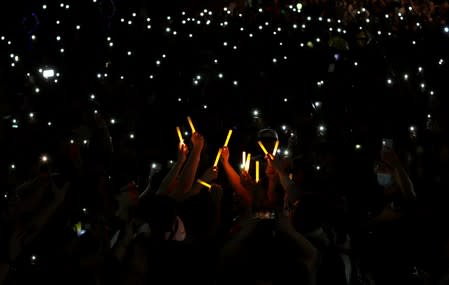 People hold up glowing sticks and mobile phones during the Mid-Autumn Festival, in Sha Tin, Hong Kong