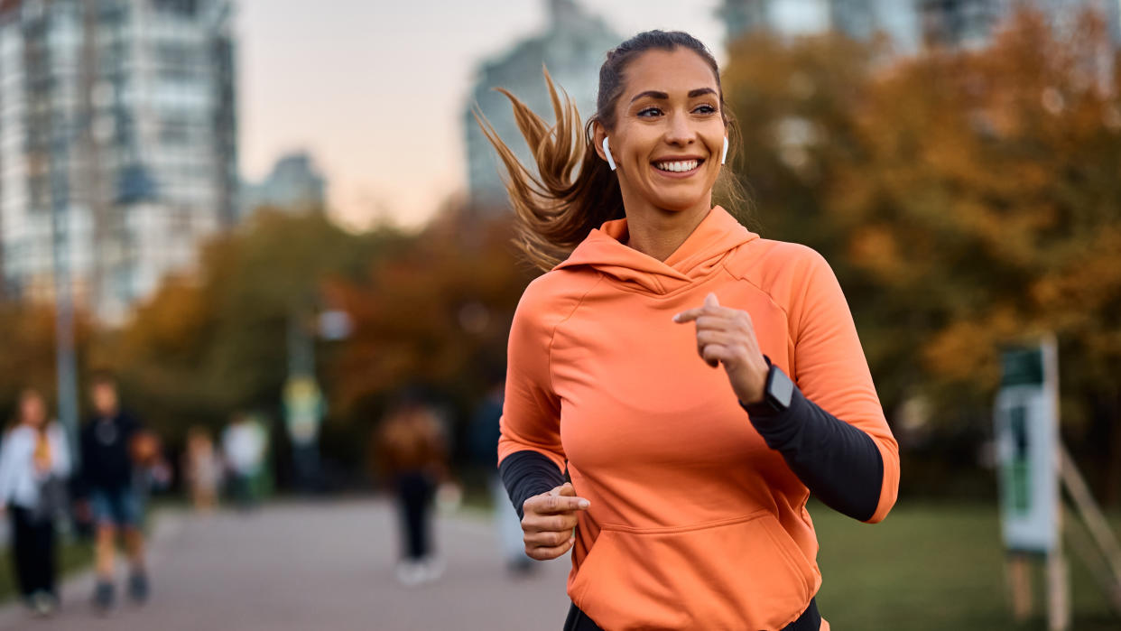  Happy woman running in park. 