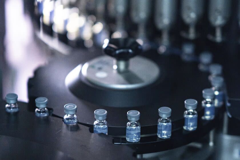 Vials of Pfizer's bivalent COVID-19 boosters on a production line in Kalamazoo, Mich.