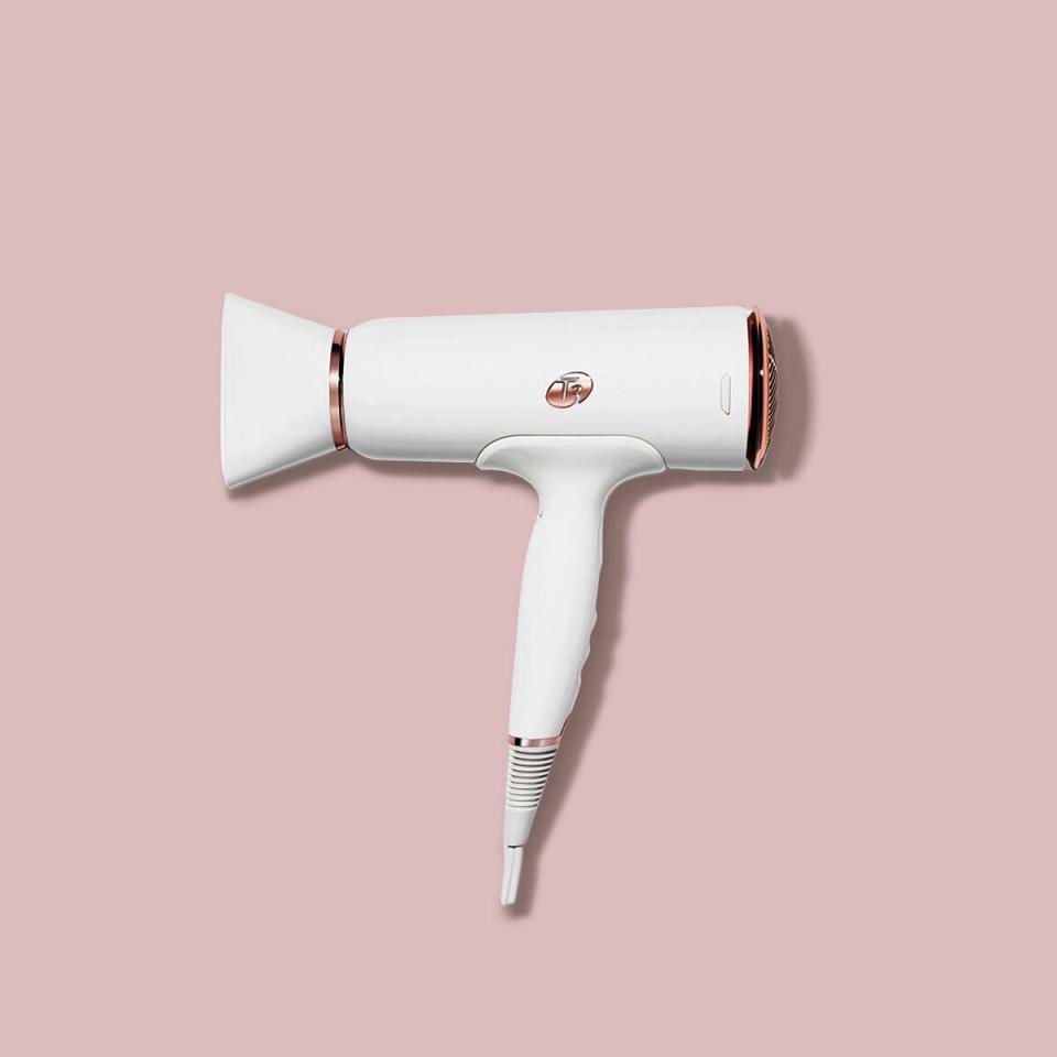 white hair dryer with rose gold accents in front of light pink background