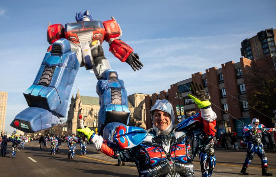 A person walks in front of the Optimus Prime parade balloon during the 96th America's Thanksgiving Parade Presented by Gardner White in Detroit on Thursday, Nov. 24, 2022.