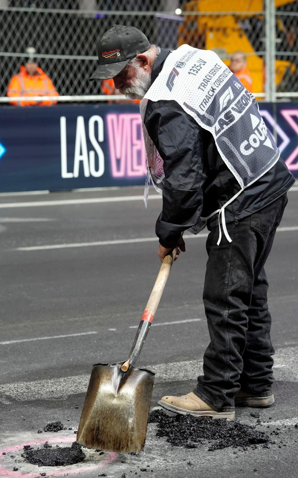 A worker fills in a hole before the start of the second practice session for the Formula One Las Vegas Grand Prix