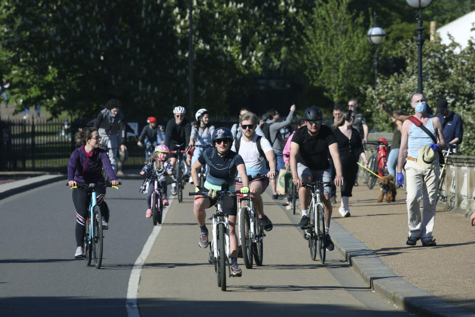 Cyclists cross the Serpentine Bridge in Hyde Park as the UK continues its lockdown to help curb the spread of coronavirus, in London, Saturday April 25, 2020. (Jonathan Brady/PA via AP)