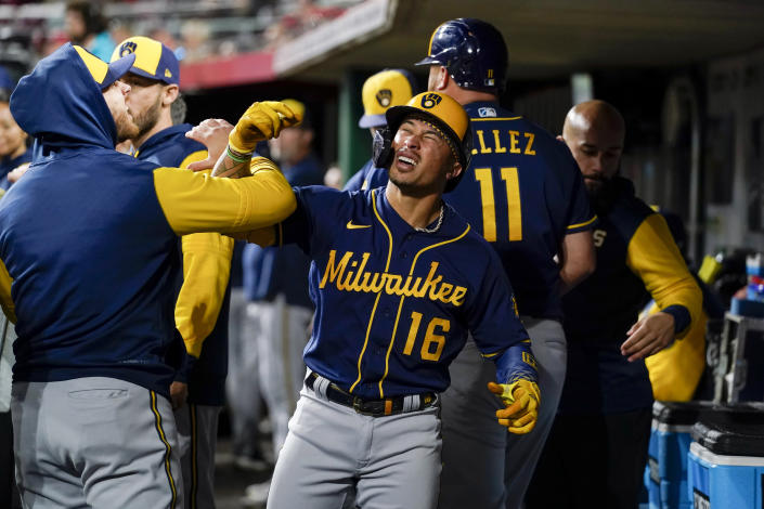 Milwaukee Brewers' Kolten Wong (16) celebrates with teammates in the dugout after his two-run home run during the sixth inning of the team's baseball game against the Cincinnati Reds on Thursday, Sept. 22, 2022, in Cincinnati. (AP Photo/Jeff Dean)