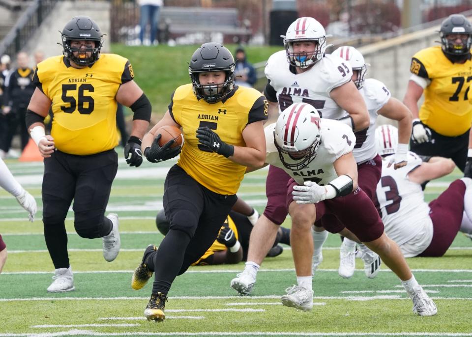 Adrian College's Tche Leroux runs with the ball for a pick-6 touchdown during Saturday's game against Alma College.