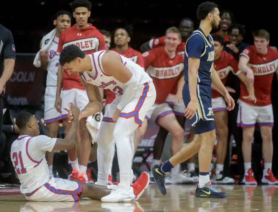 Bradley's Ja'Shon Henry helps teammate Duke Deen off the court after Deen took a foul on a three-pointer against Akron in the second half Thursday, Dec. 22, 2022 at Carver Arena. The Braves crushed the Zips 74-55.