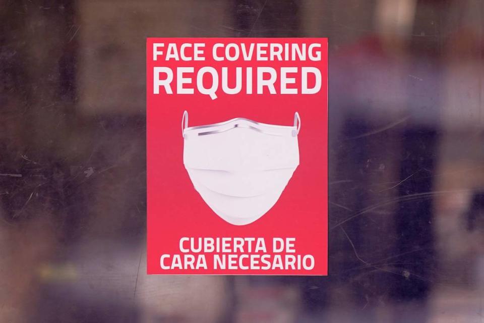 In this AP file photo from March 2, 2021, a mask required sign is displayed on the entrance to a business in Dallas. Hospitals across the state are feeling the crunch of the latest COVID-19 surge.