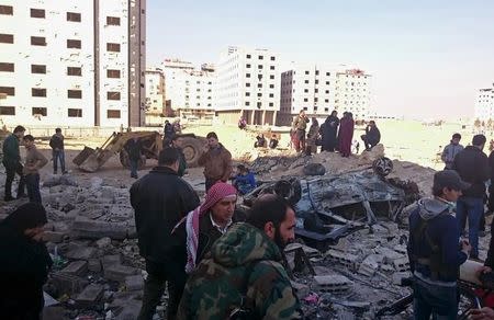 Residents and soldiers loyal to Syria's President Bashar al-Assad inspect damage after a suicide attack in Sayeda Zeinab, a district of southern Damascus, Syria January 31, 2016. REUTERS/Stringer