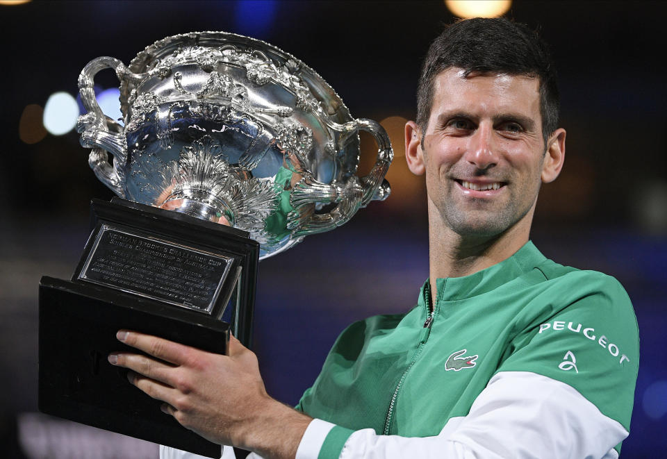FILE - Serbia's Novak Djokovic holds the Norman Brookes Challenge Cup after defeating Russia's Daniil Medvedev in the men's singles final at the Australian Open tennis championship in Melbourne, Australia, Sunday, Feb. 21, 2021. An Australian judge reinstated tennis star Novak Djokovic's visa Monday, Jan. 10, 2022, which was canceled last week because he is unvaccinated. (AP Photo/Andy Brownbill, File)