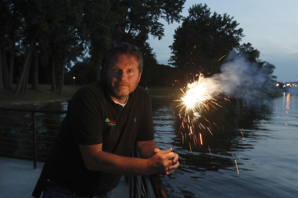 Local landscaper and chairman of Saginaw Area Fireworks, Tom Roy, holds a sparkler as he poses for a portrait Monday, June 29, 2020, in Rust Park on Ojibway Island where the city's July 4th fireworks would launch over Saginaw, Mich. Roy scrambled trying to save the display, that annually drew over 150,000 people from the area, but in the end, cancelled the event amid COVID-19 issues. "People were very upset," Roy said. "They just felt they needed it, I guess." (AP Photo/Charles Rex Arbogast)
